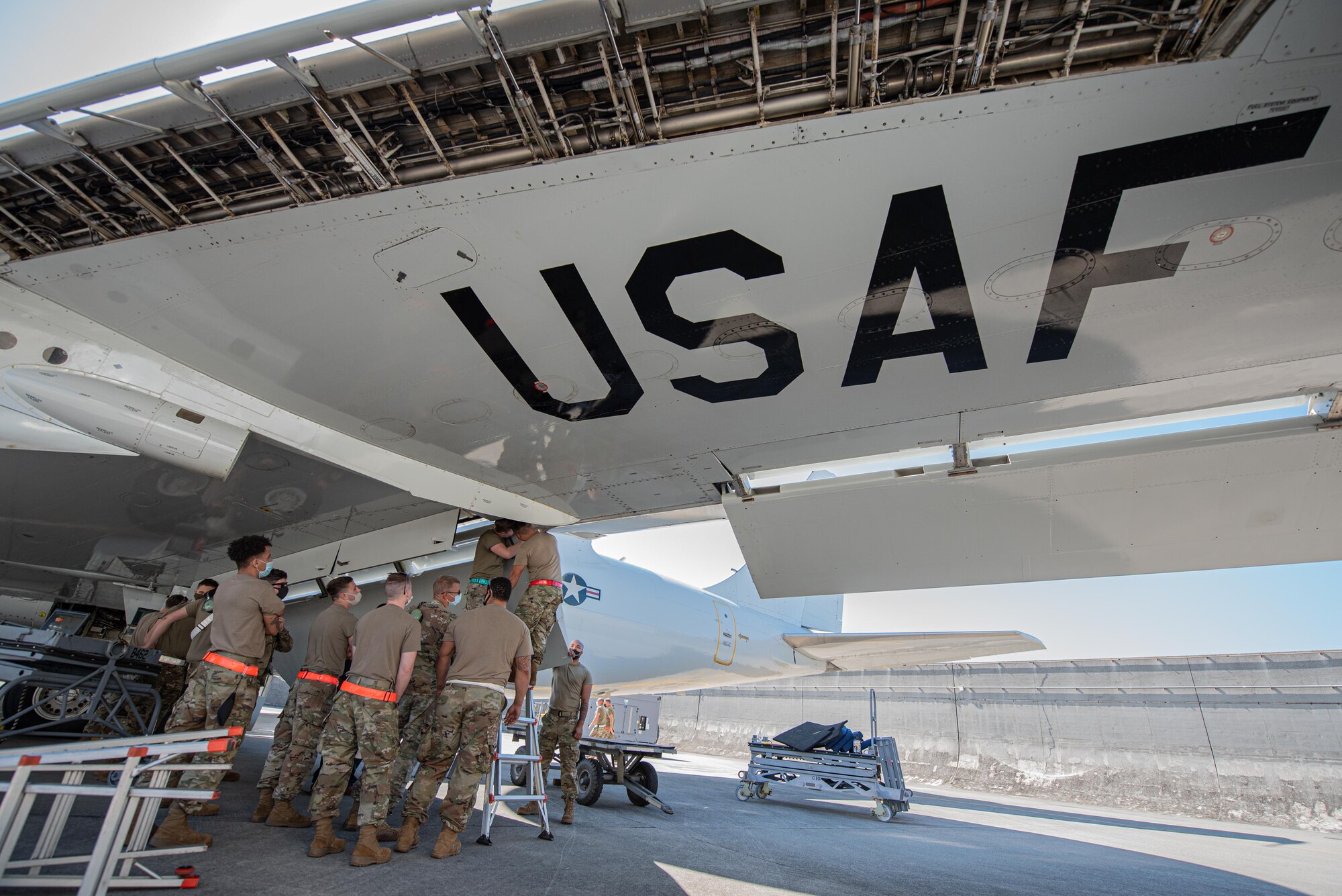 Airmen remove an aircraft wing flap.