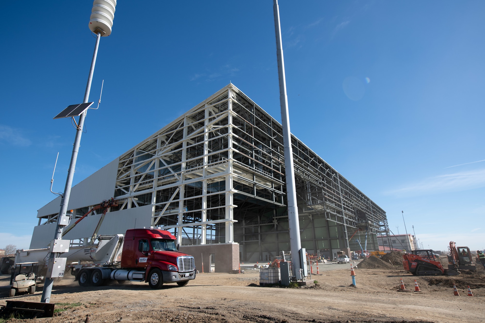 Walsh Construction crewmen install insulated wall panels during construction of the KC-46A Pegasus 3-bay maintenance hangar