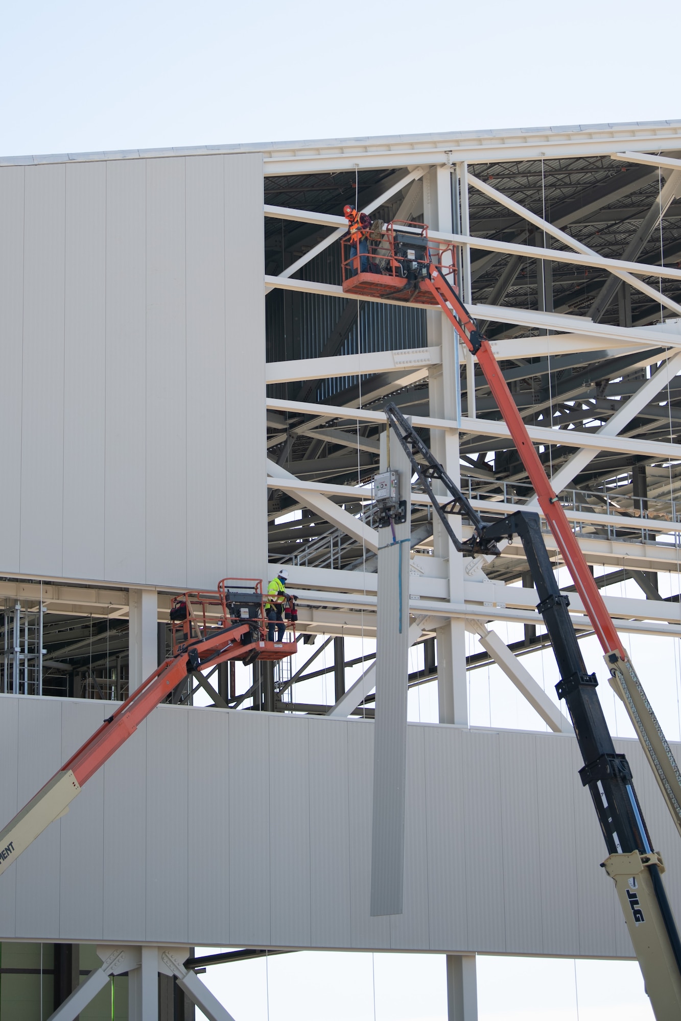 Walsh Construction crewmen install insulated wall panels during construction of the KC-46A Pegasus 3-bay maintenance hangar