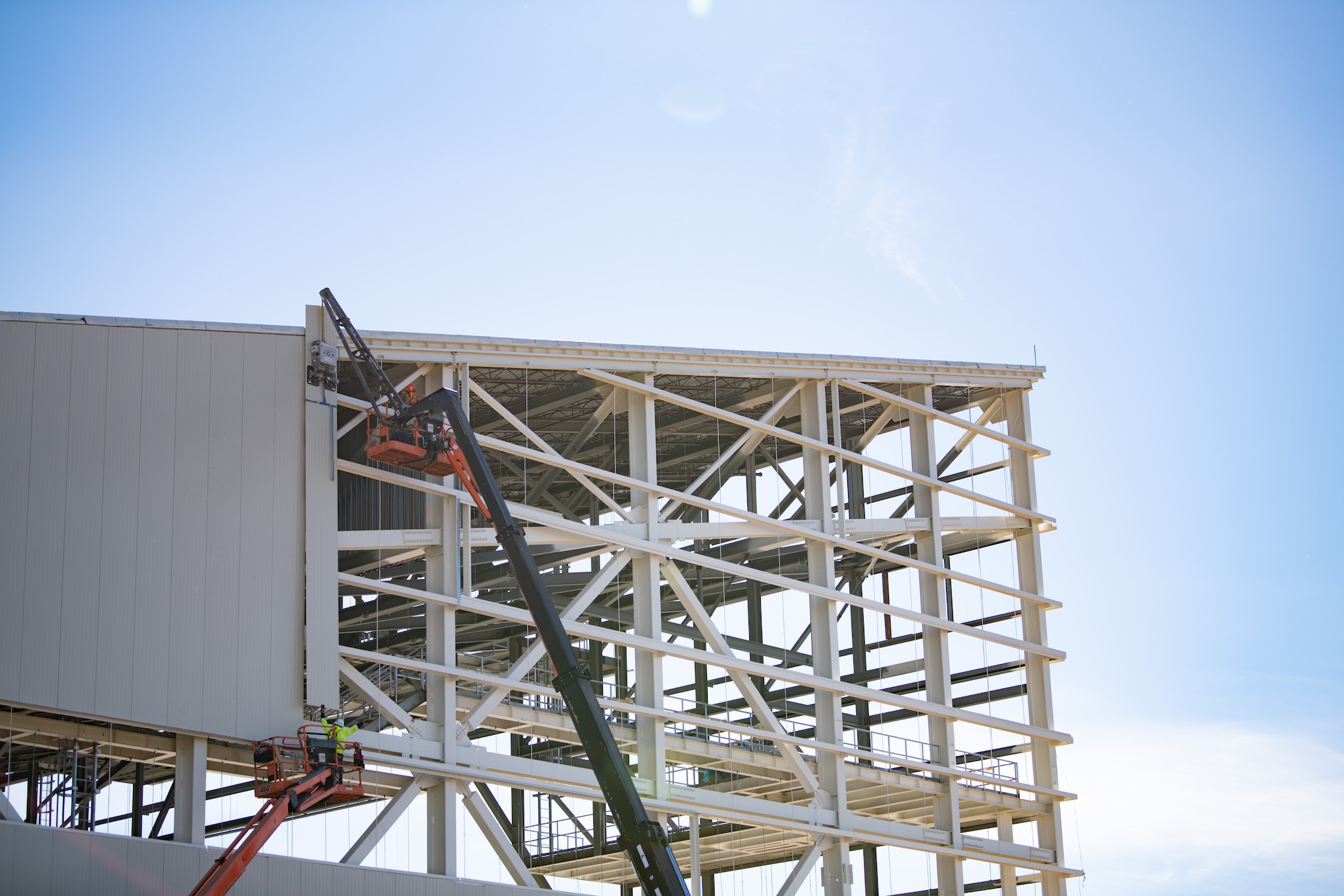 Walsh Construction crewmen install insulated wall panels during construction of the KC-46A Pegasus 3-bay maintenance hangar