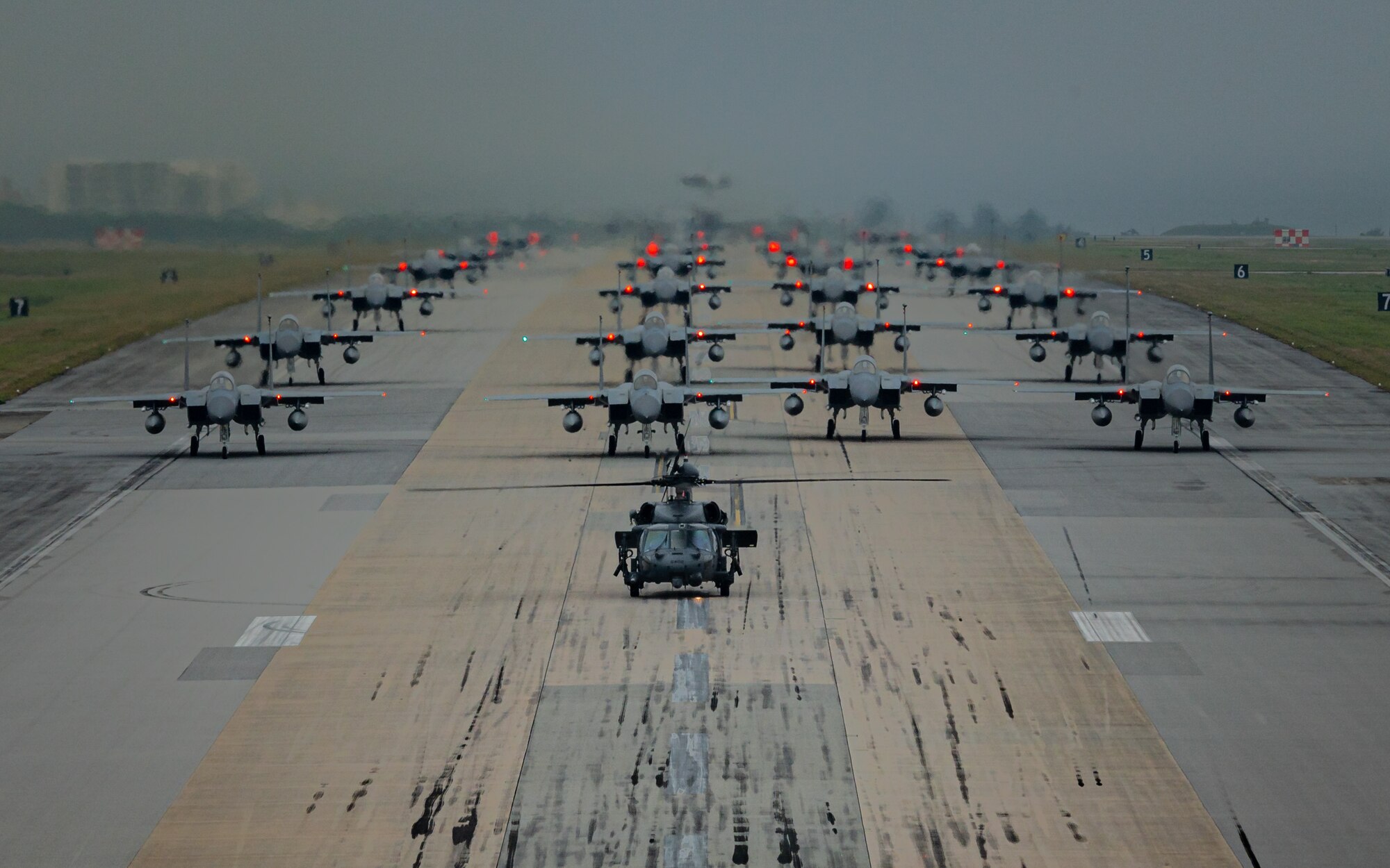 A formation of F-15C/D Eagles assigned to the 44th and 67th Fighter Squadrons, a KC-135 Stratotanker assigned to the 909th Air Refueling Squadron, an E-3 Sentry assigned to the 961st Airborne Air Control Squadron, and an HH-60 Pavehawk assigned to the 33rd Rescue Squadron taxi during a routine wing readiness exercise at Kadena Air Base