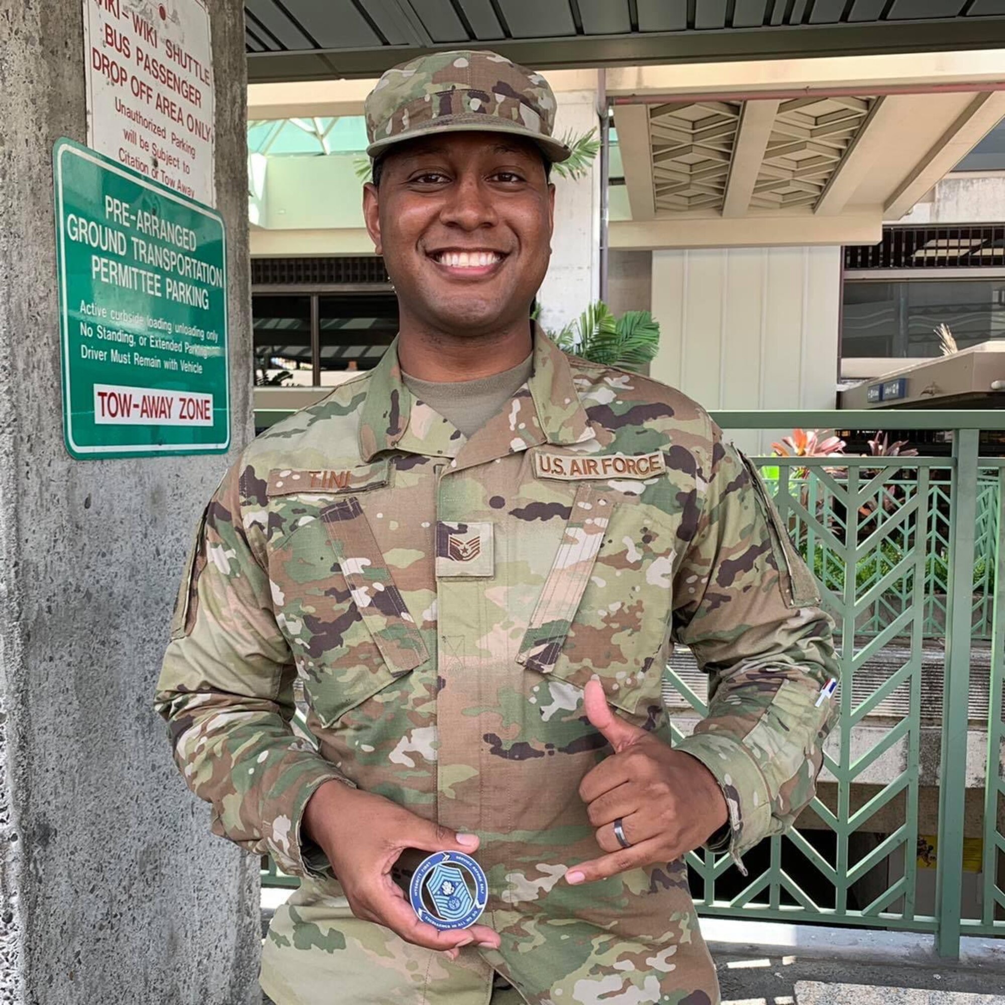 Tech. Sgt. Fredrick Tini, 15th Wing executive assistant, holds a challenge coin he received from Chief Master Sergeant of the Air Force JoAnne S. Bass during her visit to Joint Base Pearl Harbor-Hickam, Hawaii, March 1, 2022. Tini was chosen by Chief Bass as her personal selection for the Senior Leader Enlisted Commissioning Program - Officer Training School, a program for exceptionally performing, highly talented enlisted Airmen to commission through Officer Training School. (Courtesy Photo)