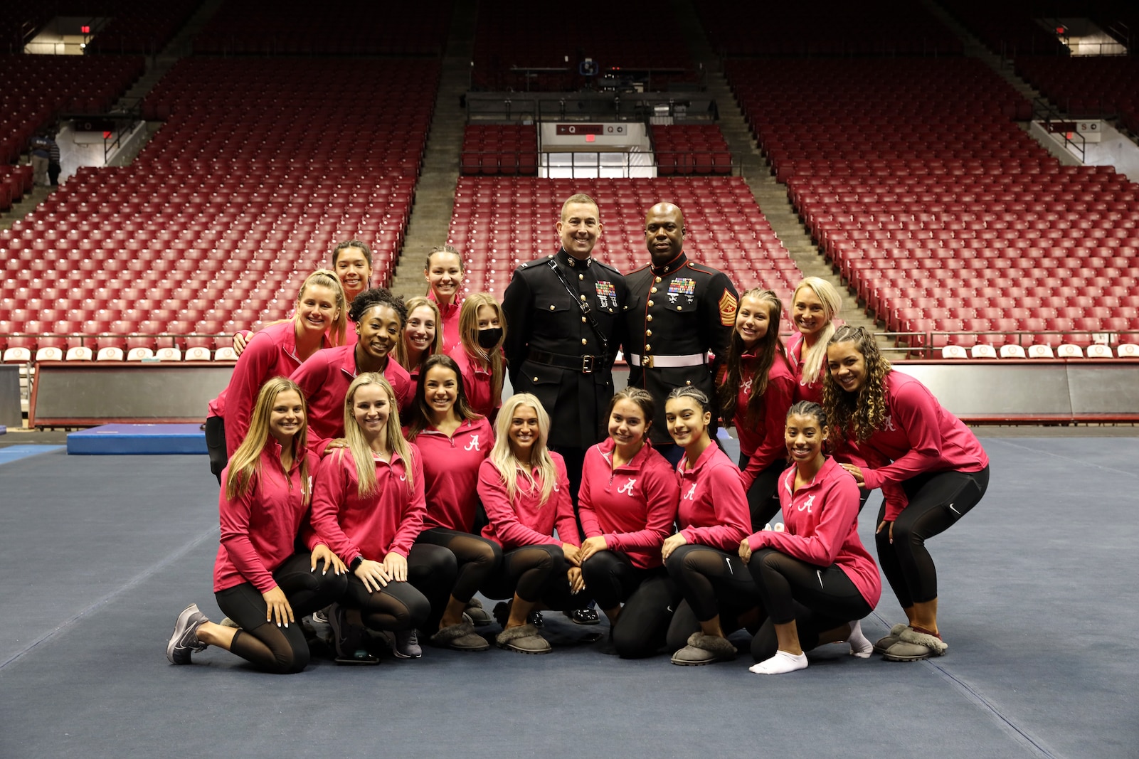 U.S. Marine Col. Lance J. Langfeldt (from left), the 6th Marine Corps District Commanding Officer, and Sgt. Maj. Frank O. Robinson, the 6th Marine Corps District Sergeant Major, stand for a photo with the University of Alabama Gymnastics team in Tuscaloosa Alabama, February 11, 2022. The Marines from 6th Marine Corps District spoke with the team about the importance of leadership and their role in the community.