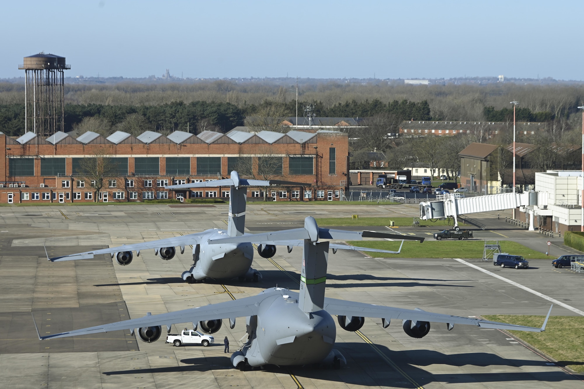 Two U.S. Air Force C-17 Globemaster III aircraft assigned to the 60th Air Mobility Wing, Travis Air Force Base, Calif., and the 62nd Airlift Wing, Joint Base Lewis-McChord, Wash., sit on the flightline after landing at Royal Air Force Mildenhall, England, Feb. 27, 2022. The aircraft landed at RAF Mildenhall after transporting cargo pallets to an air base in Norway. (U.S. Air Force photo by Senior Airman Joseph Barron)