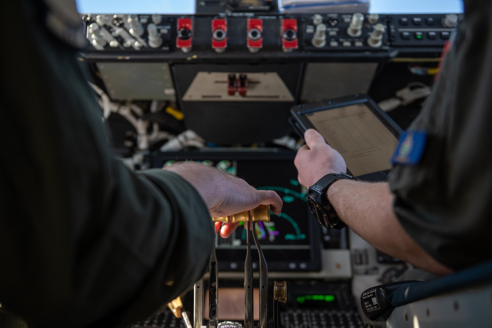 Two pilots sit in a cock pit inside of a KC-135