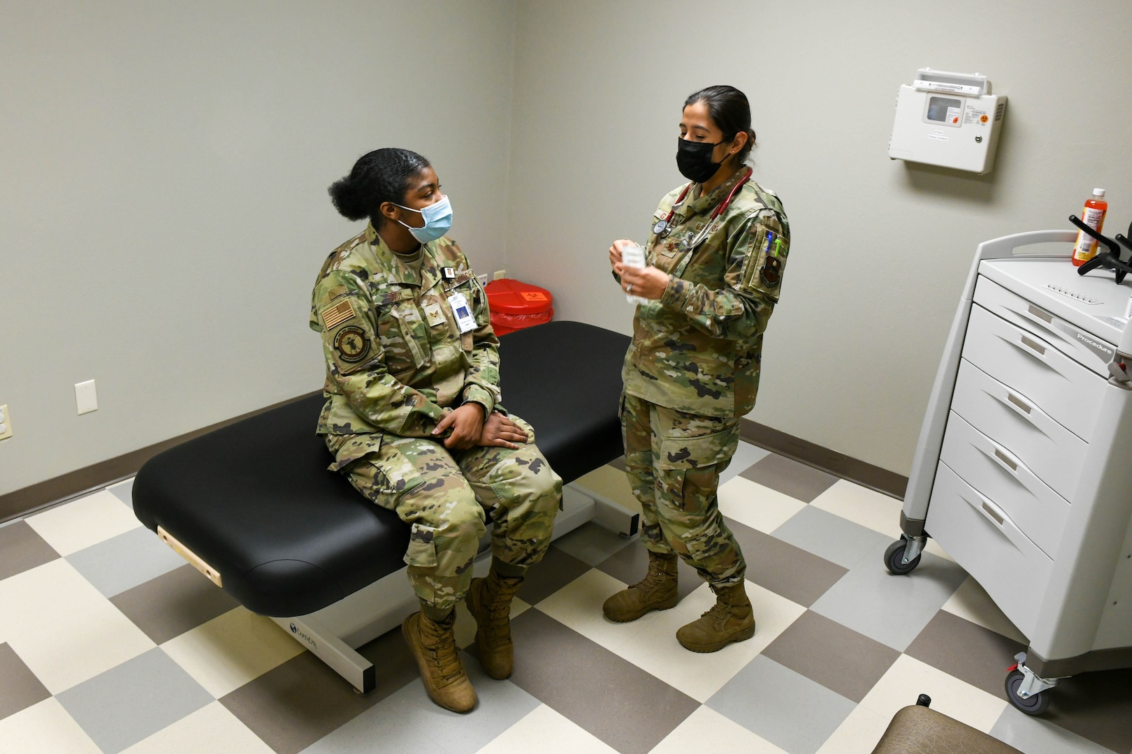 Dr. Jessica Gamboa, 97th Medical Group (MDG) chief of medical staff, explains what battlefield acupuncture is to Senior Airman Alexzandria Body, 97th Operational Medical Readiness Squadron pediatric and family health front desk clerk, at Altus Air Force Base, Oklahoma, Feb. 10, 2022. Acupuncture is one of the new services the MDG offers, including osteopathic manipulative treatment. (U.S. Air Force photo by Airman 1st Class Trenton Jancze)