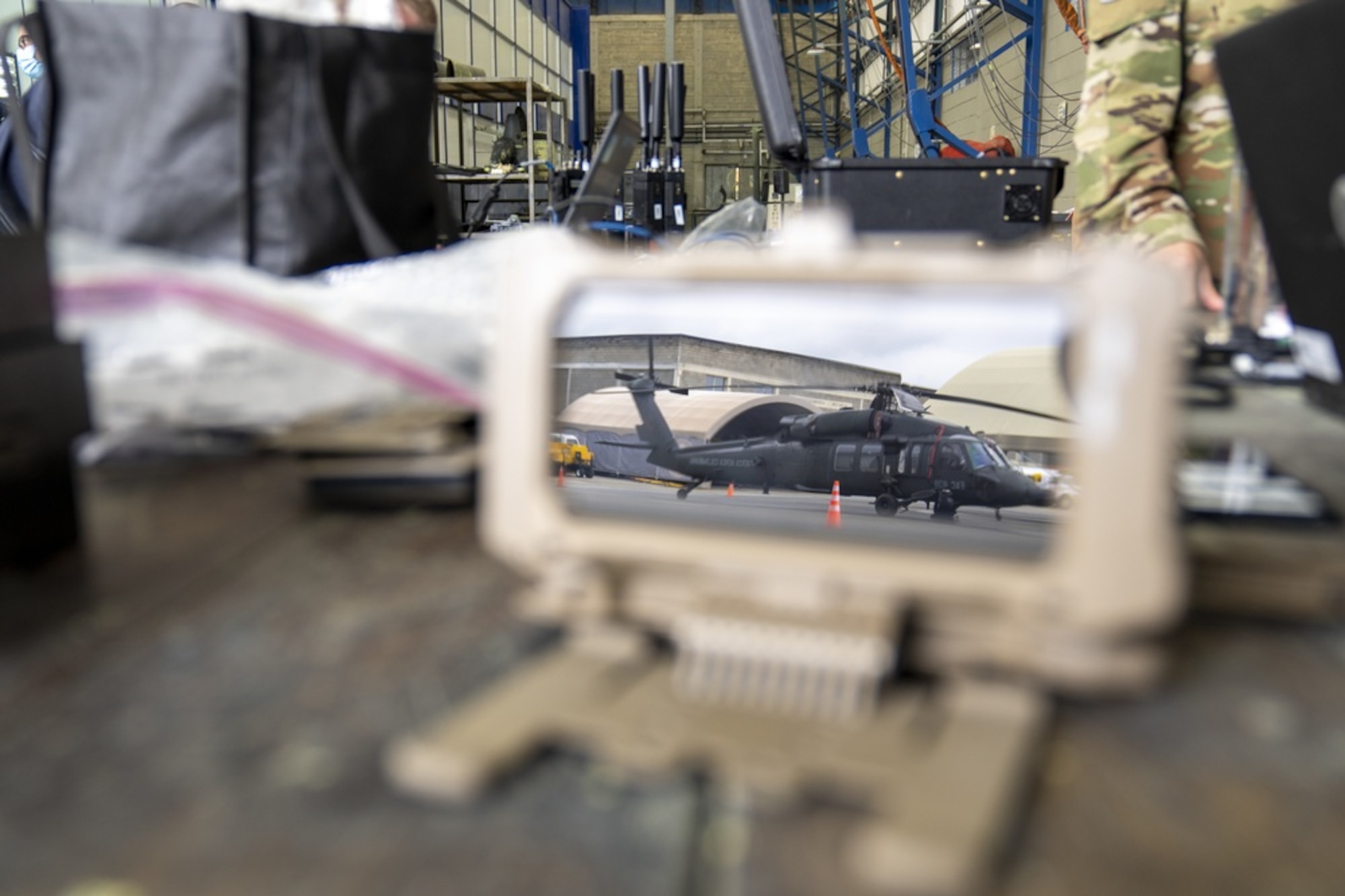 A Colombian Air Force HH-60 parked on the flightline is reflected on a cell phone linked to the AERONet system during the Ángel de los Andes exercise outside of Rionegro, Colombia, in September 2021. During the exercise, personnel from the Quick Reaction Capability Branch, headquartered at Hanscom Air Force Base, Mass., were able to utilize AEROnet in two separate operating locations to deliver real-time command and control data back to the Tactical Operations Center.