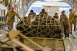 Airmen load cargo on an aircraft.