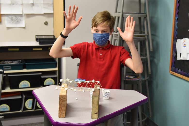 A student reacts with relief as his bridge constructed with toothpicks and marshmallows successfully holds the weight of a toy car during a learning session with the U.S. Army Corps of Engineers – Alaska District on Feb. 23 at Pacific Northern Academy in Anchorage.