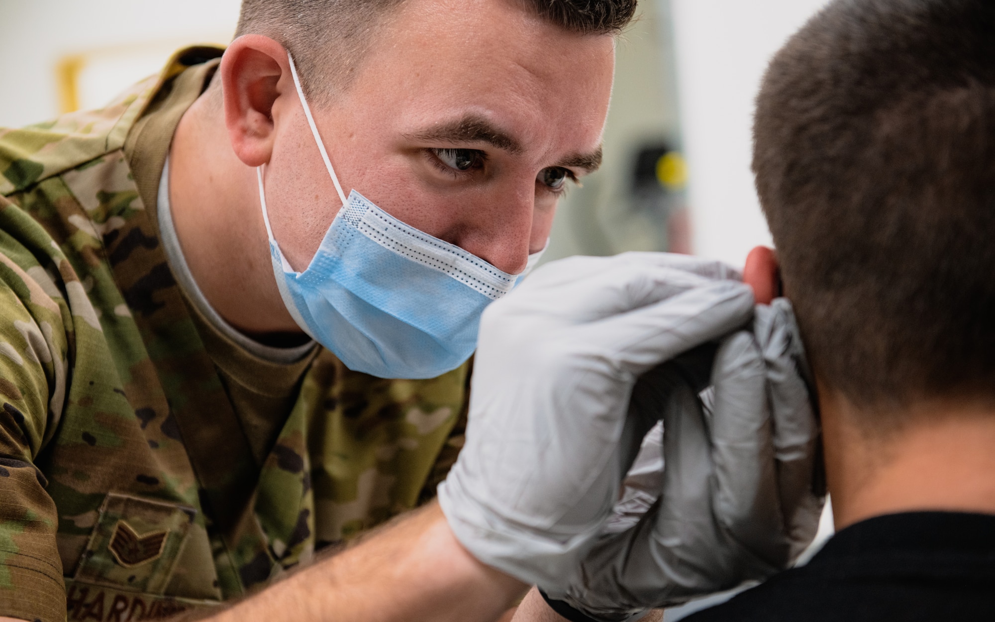 Airman performs acupuncture on soldier.