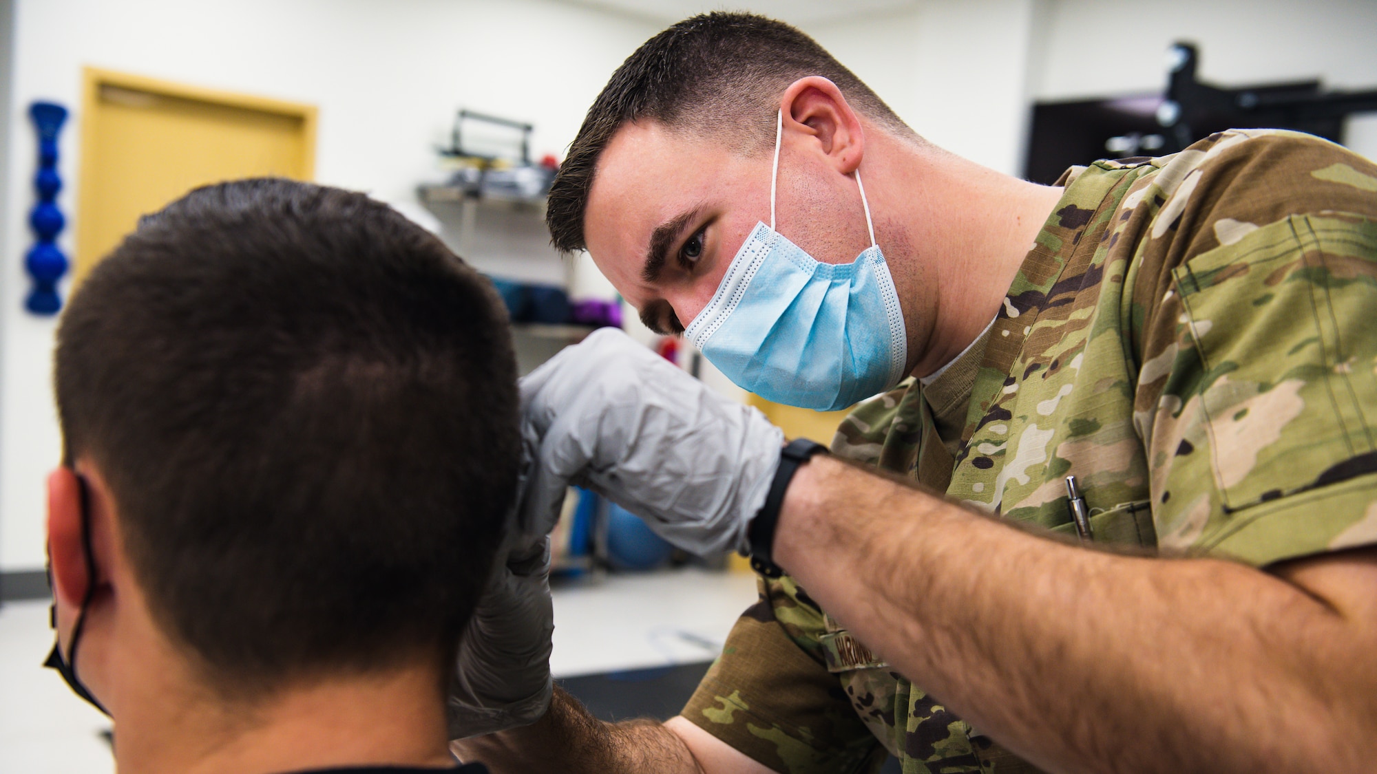 Airman performs acupuncture on soldier.