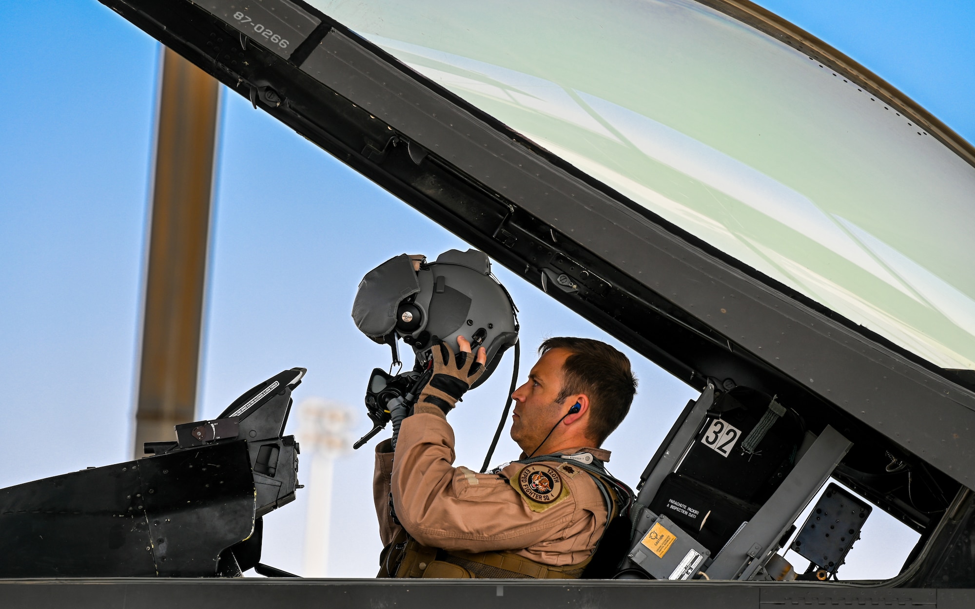 A 176th Expeditionary Fighter Squadron pilot dons his helmet in the cockpit of an F-16 Fighting Falcon in preparation for take off at King Abdulaziz Air Base, Kingdom of Saudi Arabia, Feb. 17, 2022. The ability to work with other nations and move fluidly across the theater is key to ensuring readiness. (U.S. Air Force photo by Staff Sgt. Christina A. Graves)
