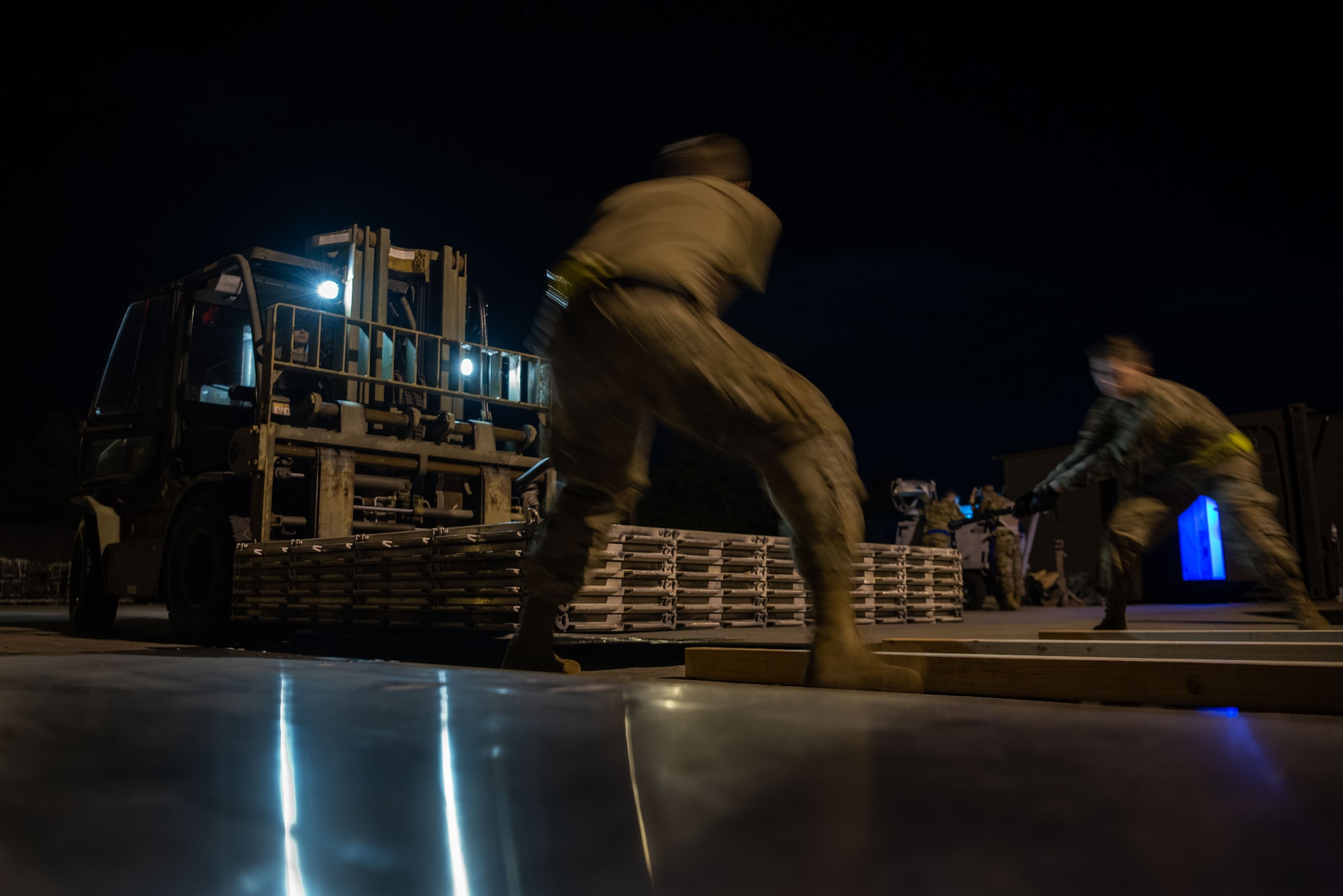 Airmen work to move munitions at night.