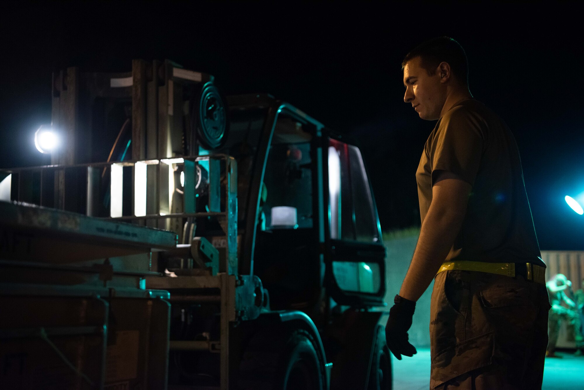 Airmen work to move munitions at night.