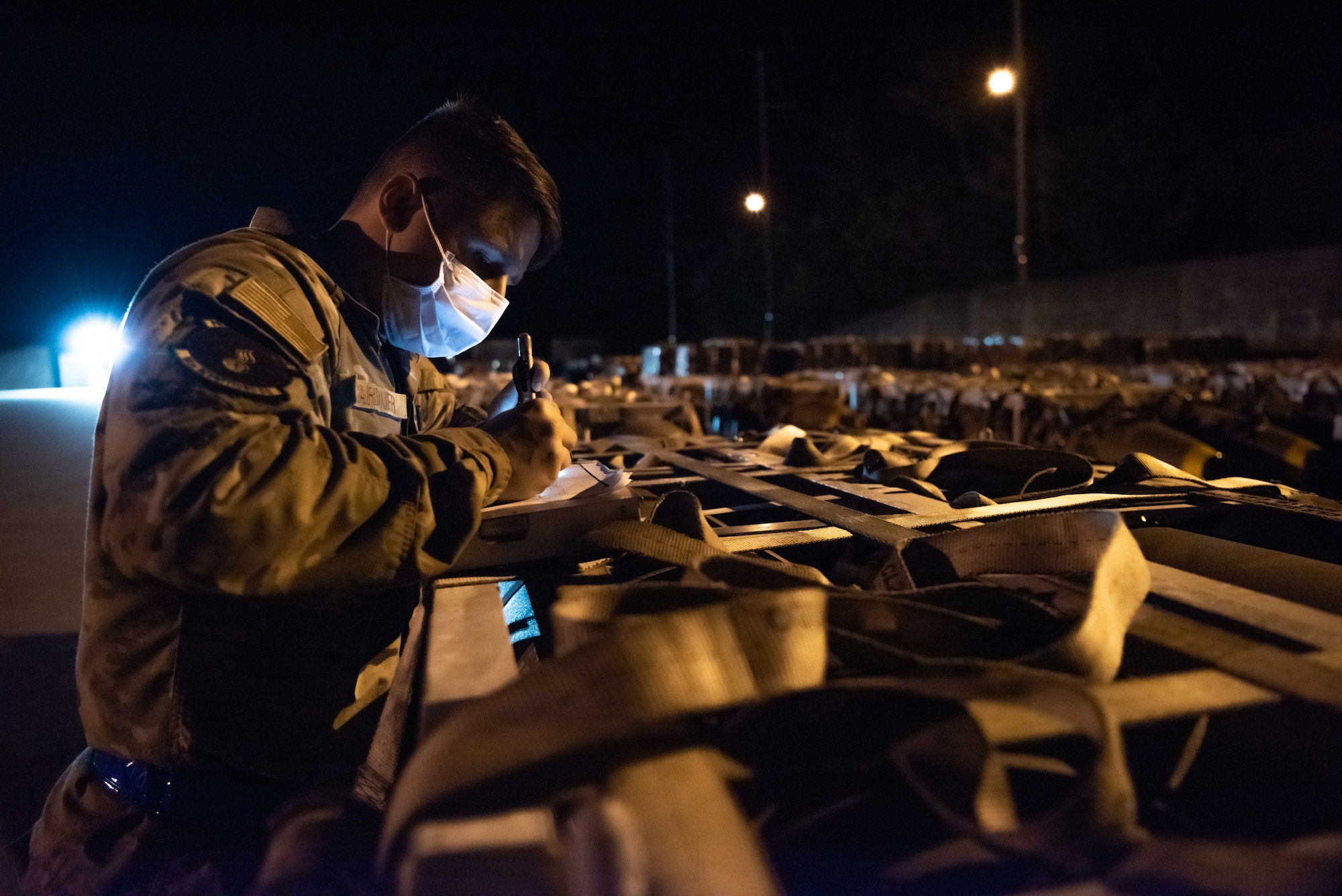 Airmen work to move munitions at night.