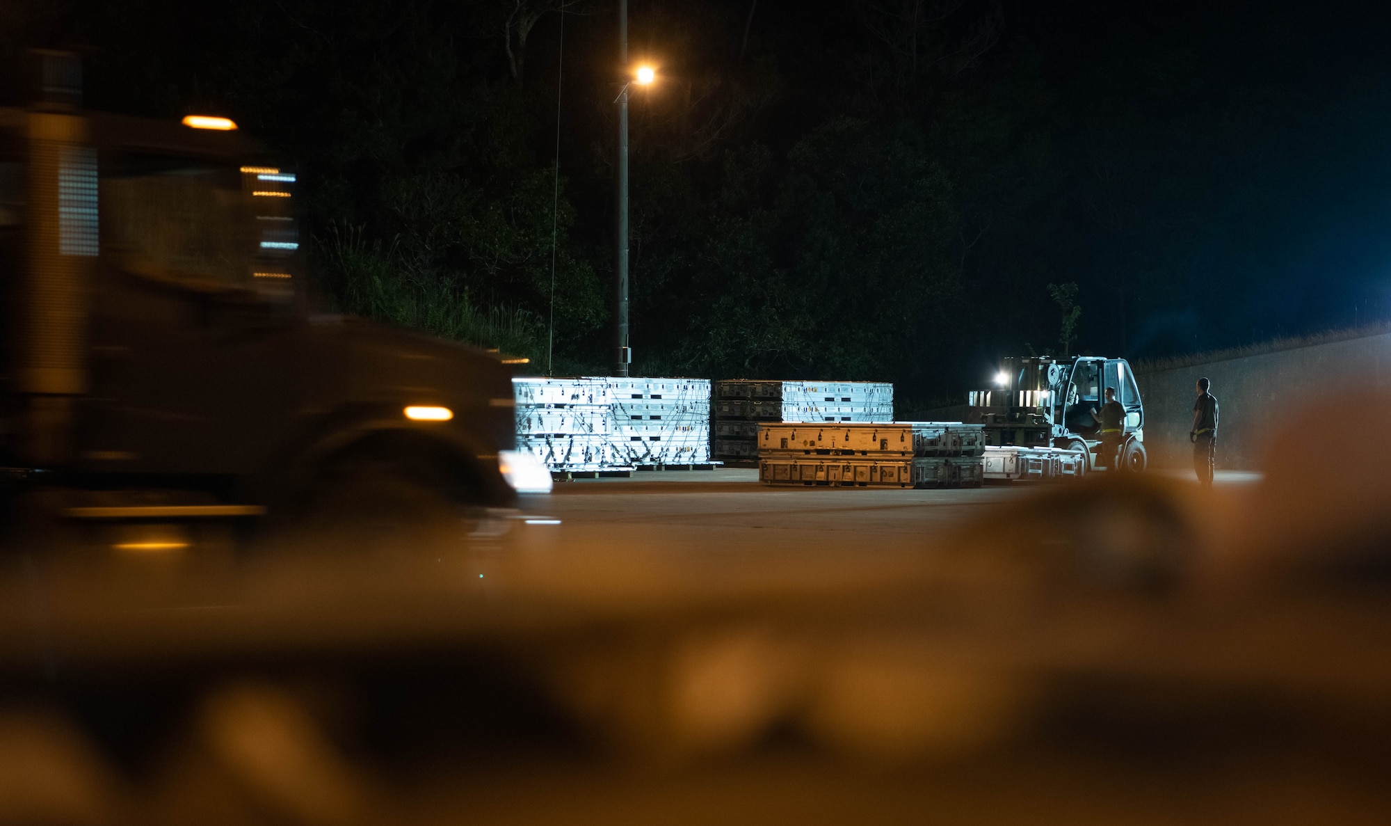 Airmen work to move munitions at night.