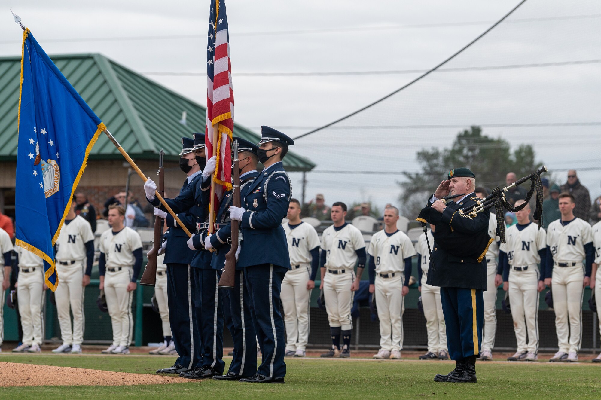 Airmen from the 4th Fighter Wing Honor Guard salute during the singing of the National Anthem at the 12th Annual Freedom Classic baseball series at Grainger Stadium in Kinston, North Carolina on Feb. 26, 2022. The Naval Academy won the series 2-1 over the Air Force Academy. (U.S. Air Force photo by Airman 1st Class Kevin Holloway)