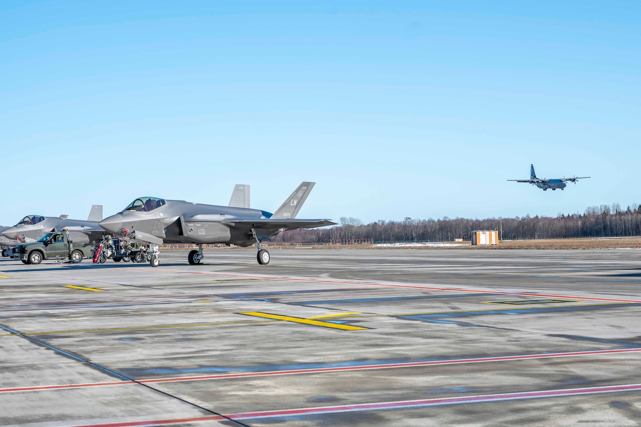 An aircraft lands on a flightline.