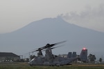 Two aircraft sit inert in front of an active volcano.