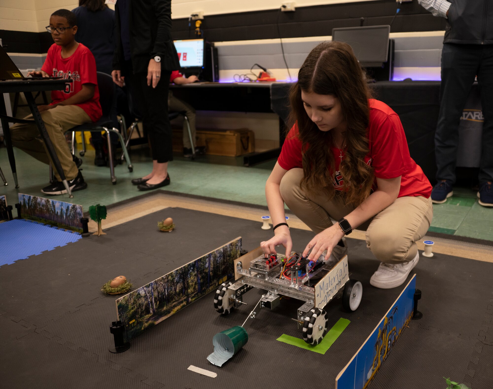Girl placing robot on the ground.