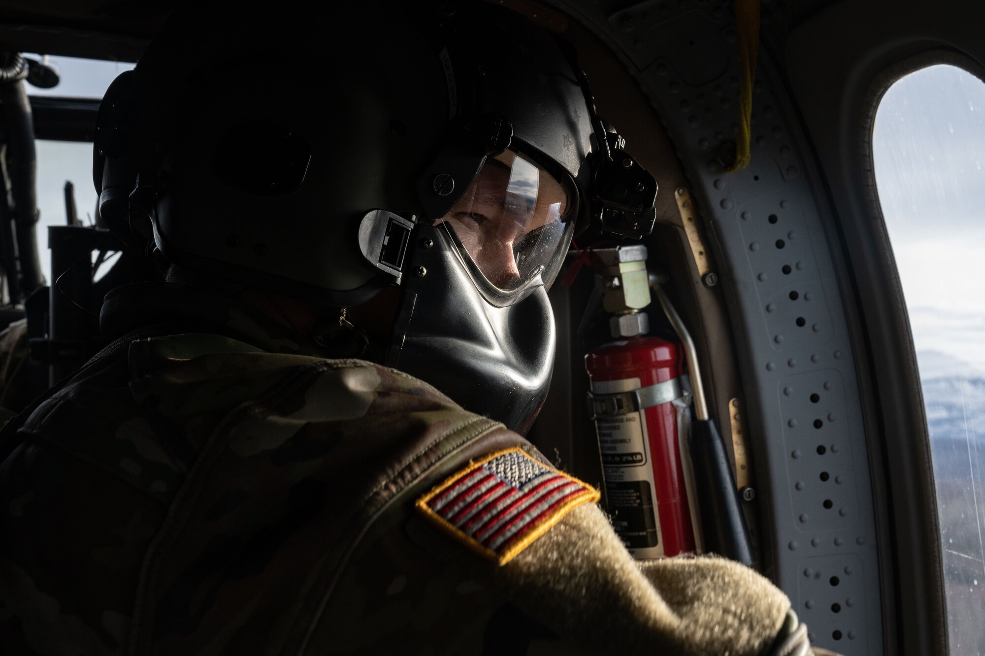 An Alaska Army National Guardsman sits in a UH-60L Blackhawk.