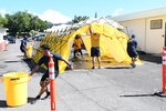 Sailors in hazmat gear complete outdoor training.