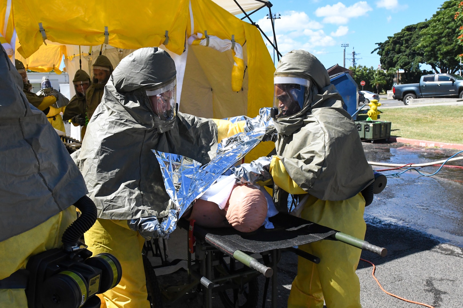 Sailors in hazmat gear complete outdoor training.