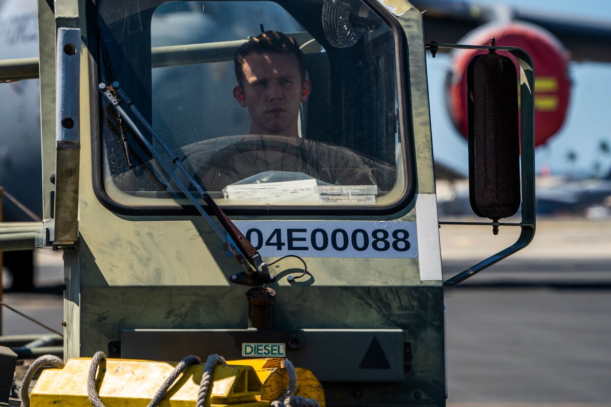 Staff Sgt. Waite Rowland, 647th Logistics Readiness Squadron combat mobility flight supervisor, prepares to load cargo from a 25k Halvorsen during Exercise TROPIC FURY at Joint Base Pearl Harbor-Hickam, Hawaii, March 2, 2022. The first phase of the exercise emphasizes JBPHH Air Force readiness to combat future operations in the Pacific region by showing its capability to deploy equipment and aircraft anytime, anywhere. (U.S. Air Force photo by Airman 1st Class Makensie Cooper)