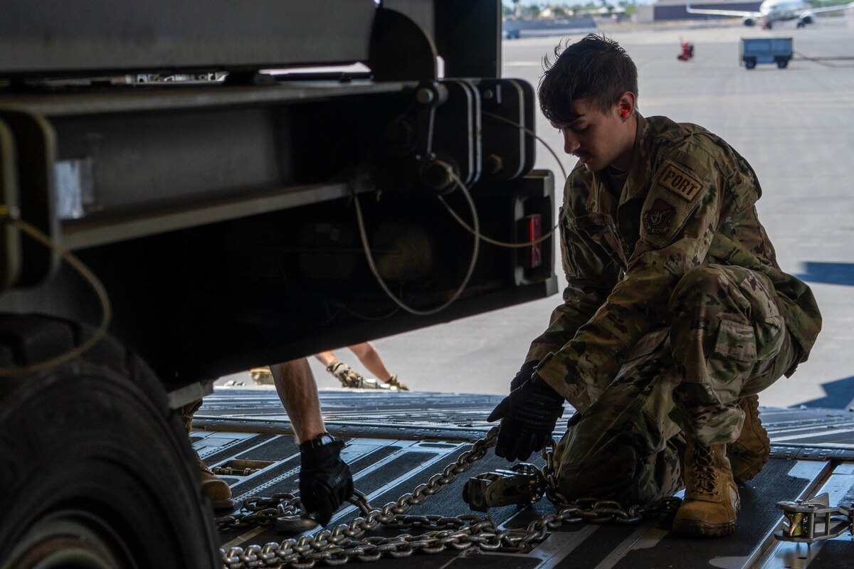 Senior Airman Cameron Foster, 647th Logistics Readiness Squadron airlift transportation function supervisor, secures a 25k Halvorsen onto a C-17 Globemaster III during Exercise TROPIC FURY at Joint Base Pearl Harbor-Hickam, Hawaii, March 2, 2022. The 647th LRS is responsible for ensuring passengers and cargo are loaded onto aircraft safely and efficiently in support of 15th Wing airlift operations. (U.S. Air Force photo by Airman 1st Class Makensie Cooper)