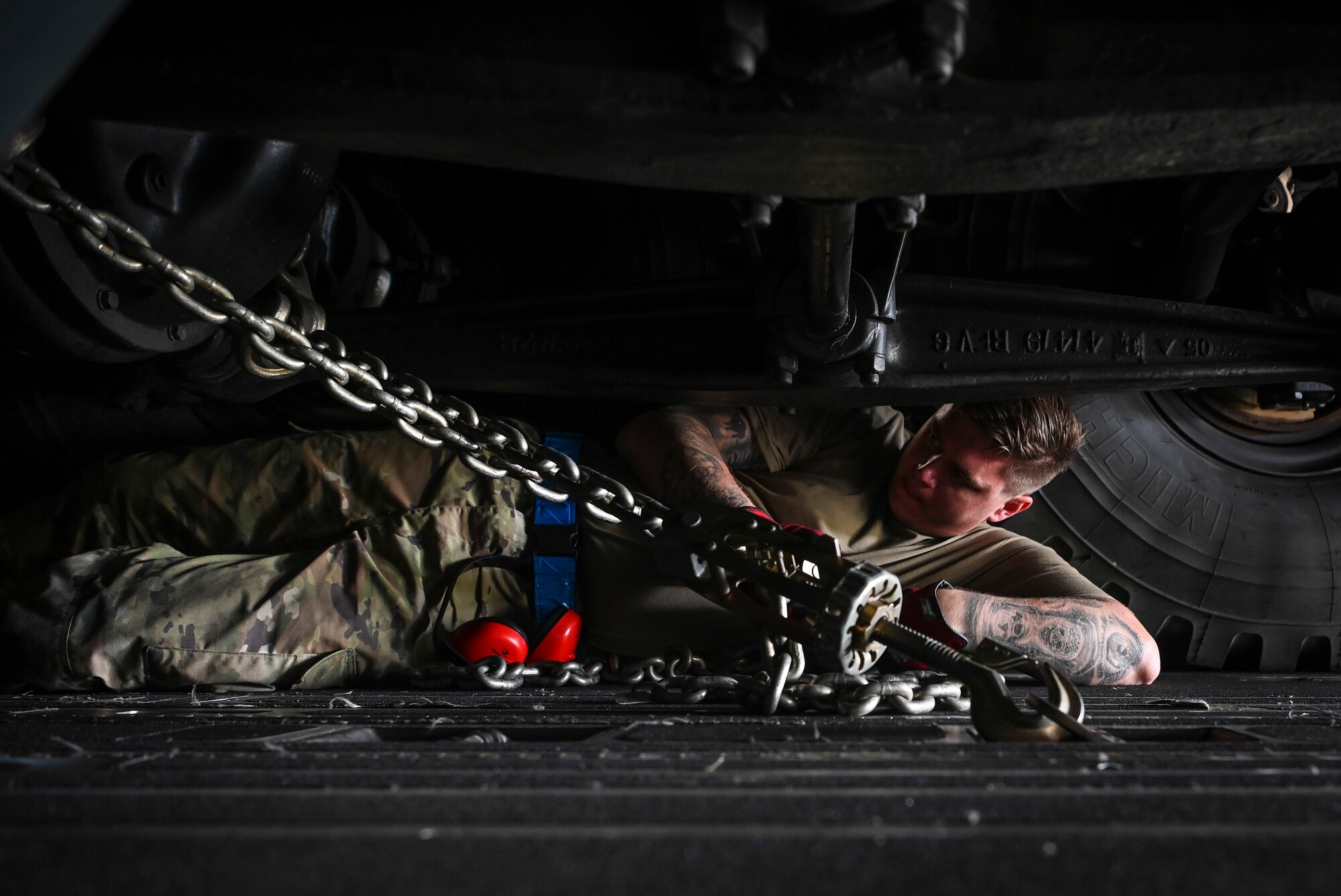 U.S. Air Force Staff Sgt. Blake Breeden, aerial port supervisor assigned to the 732nd Air Mobility Squadron, Joint Base Elmendorf-Richardson, Alaska, chains down equipment onto a C-17 Globemaster III during Operation Talon Lightning on Andersen Air Force Base, Guam, March 4, 2022.