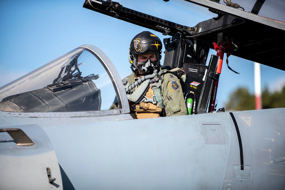 Pilot gazes from an open cockpit.