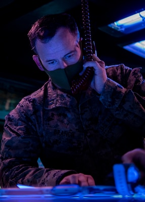 PACIFIC OCEAN (March 1, 2022) U.S. Marine Capt. Austin Branch, from Coronado, California, assigned to the U.S. Marine Corps Fifth Air Naval Gun Liaison Company (5th ANGLICO), simulates Naval Surface Fire Support (NSFS) with the Japanese Ground Self-Defense Force (JGSDF) in the Combat Information Center aboard the Arleigh Burke-class guided-missile destroyer USS Dewey (DDG 105) while participating in bilateral advanced warfare training (BAWT). BAWT is an annual bilateral training exercise that improves the partnership between U.S. and Japanese Forces. This year’s exercise focused on enhancing readiness and interoperability of coalition forces from the U.S. and Japan Maritime Self-Defense Force. (U.S. Navy photo by Mass Communication Specialist 1st Class Benjamin Lewis)