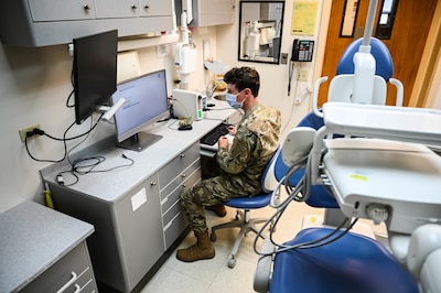 Airman 1st Class Paul Hasler, 15th Medical Group Medical Information Systems Flight technician, reimages a medical workstation in the dental clinic at Joint Base Pearl Harbor-Hickam, Hawaii, Feb. 24, 2022. The flight configured, deployed and tested more than 200 new pieces of hardware for Medical Healthcare System Genesis, which was brought online Sept. 25, 2021. (U.S. Air Force photo by Staff Sgt. Alan Ricker)