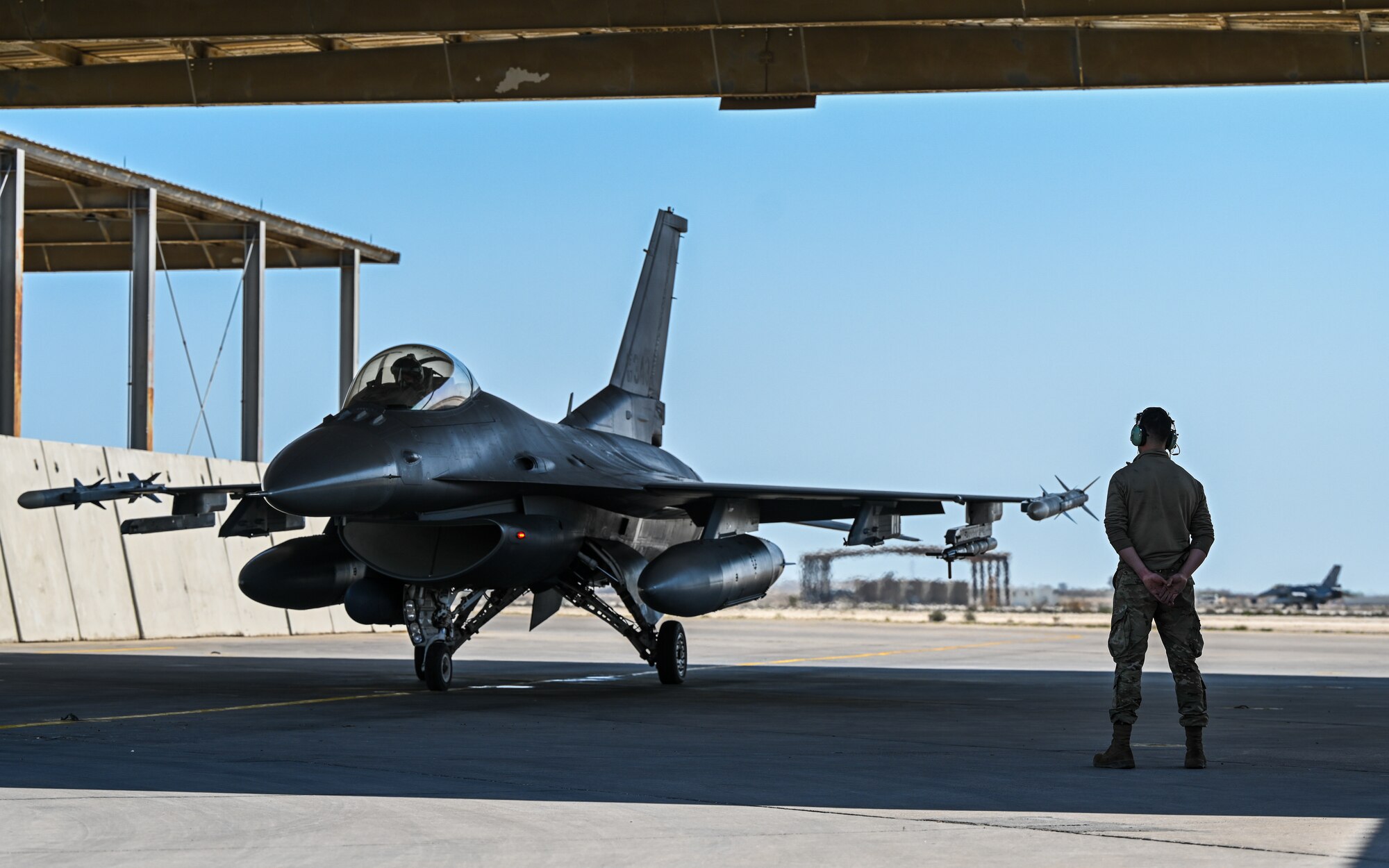 U.S. Air Force Tech. Sgt. Van Fossan, 378th Expeditionary Maintenance Squadron crew chief, conducts pre-flight checks for an F-16 Fighting Falcon at King Abdulaziz Air Base, Kingdom of Saudi Arabia, Feb. 16, 2022. Service members from the U.S., KSA, Pakistan and Bahrain conducted combined operations to better integrate partner capabilities. (U.S. Air Force photo by Staff Sgt. Christina A. Graves)