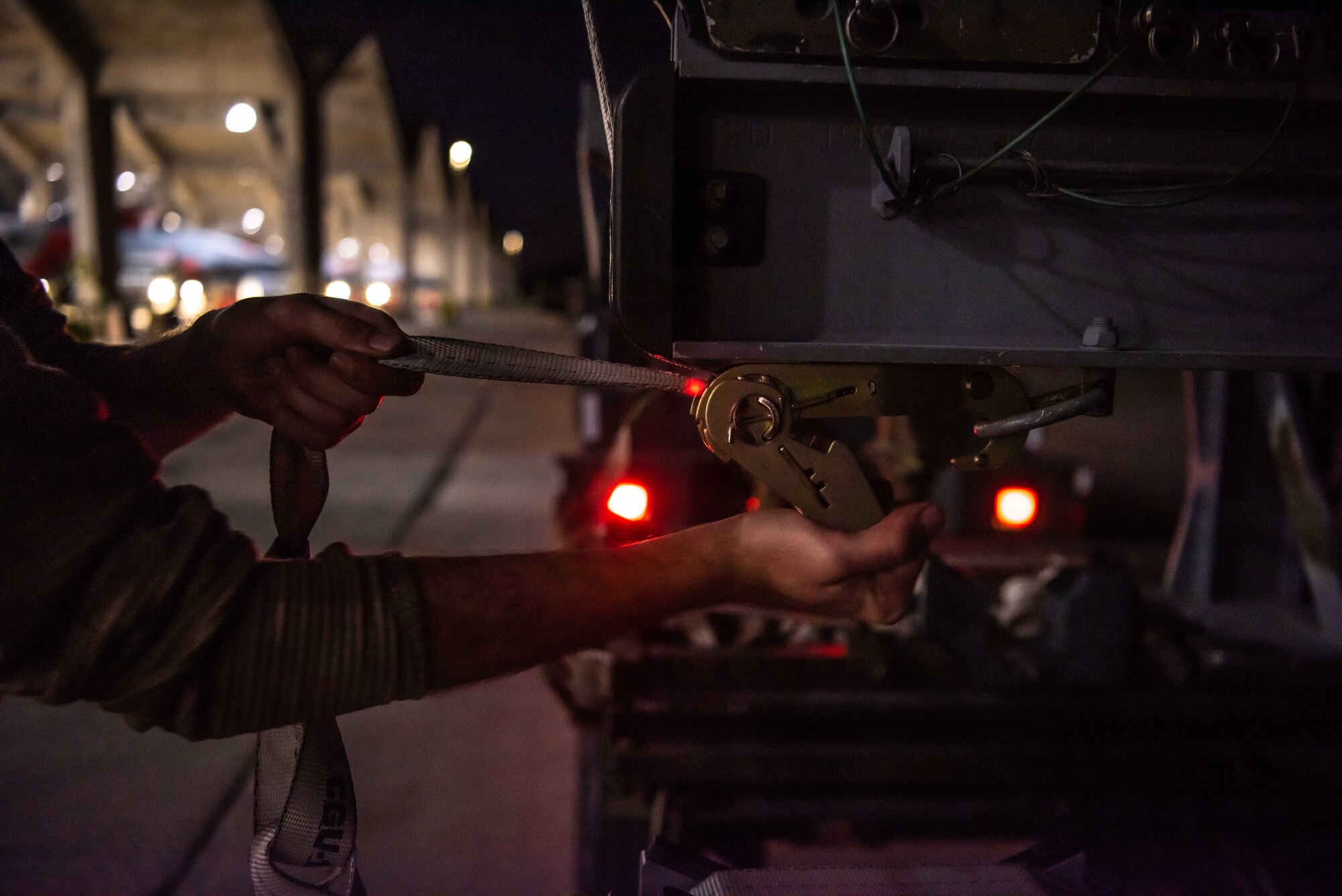 Airmen download munitions from a F-15C Eagle at dusk.