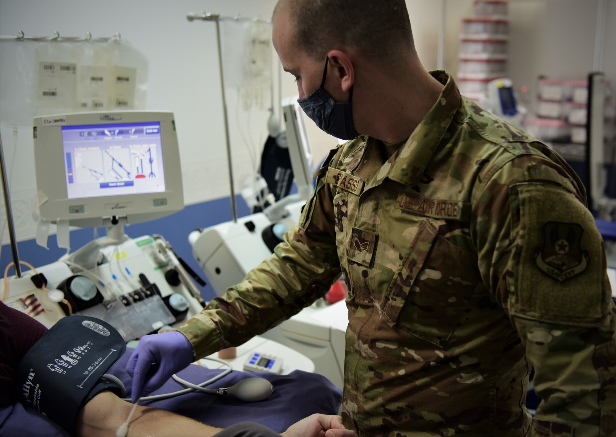 Military member draws blood from patient.