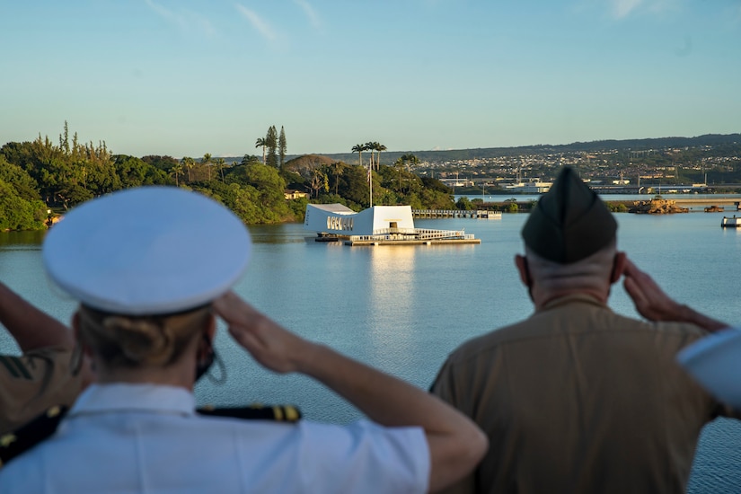 Marines and sailors  salute the USS Arizona Memorial.