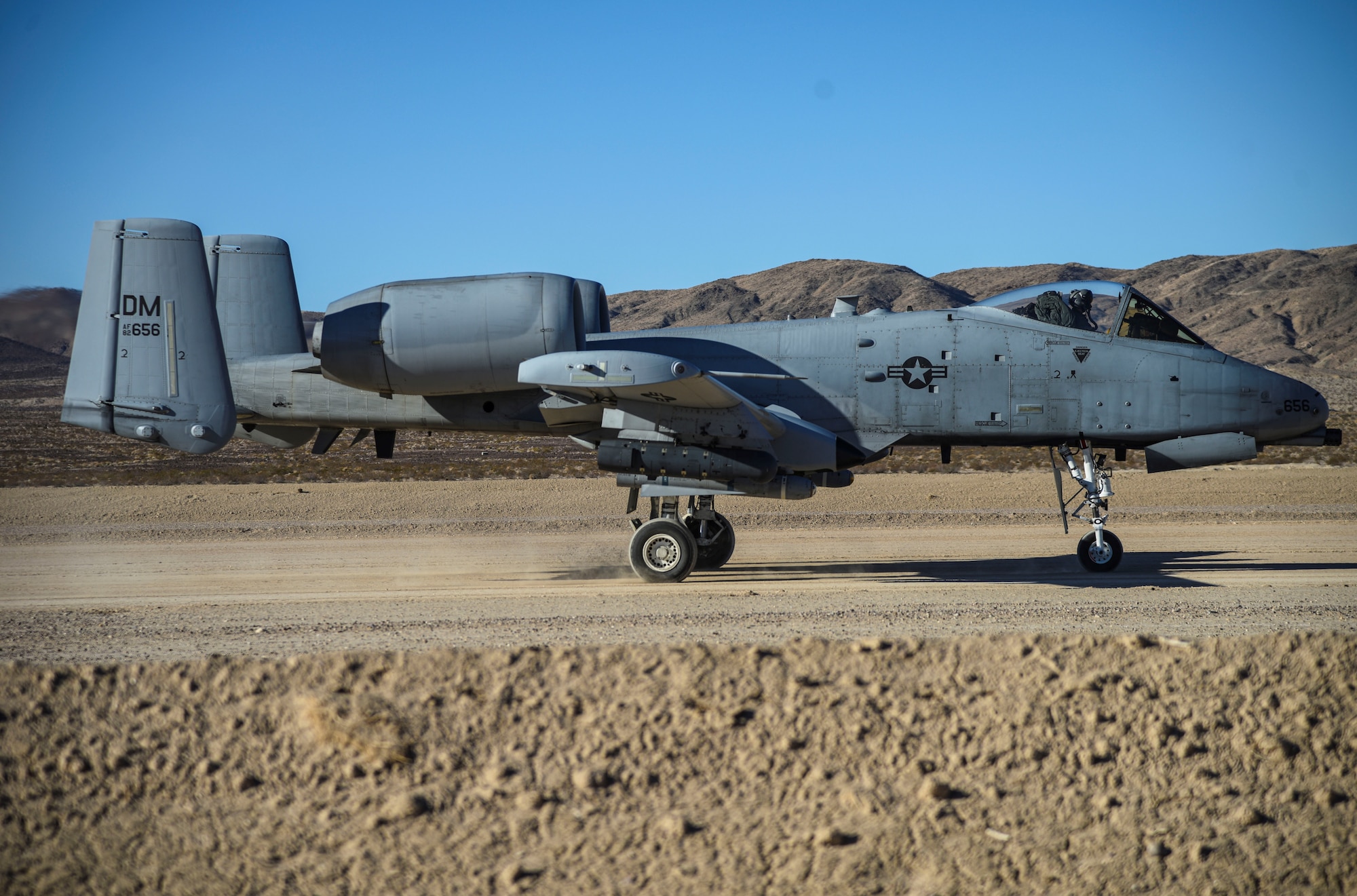 An aircraft lands on a dirt road.