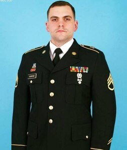 man standing in an army uniform with a blue background.