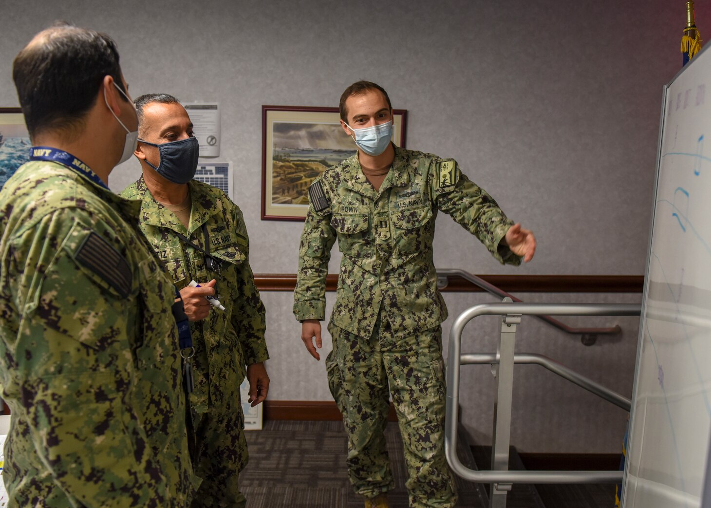 Lt. Maxwell Brown, right, assigned to Navy Reserve C10F Navy Information Operations Command Hawaii, and Capt. William Ortiz, middle, deputy director, maritime space cyber fires and effects coordination cell, discuss a diagram in the Fleet Cyber Command/U.S. 10th Fleet situation room during Exercise Keen Edge. Keen Edge is a bilateral command post exercise conducted to increase combat readiness and synchronization between the U.S. and Japan . (U.S. Navy photo by Mass Communication Specialist 2nd Class William Sykes)