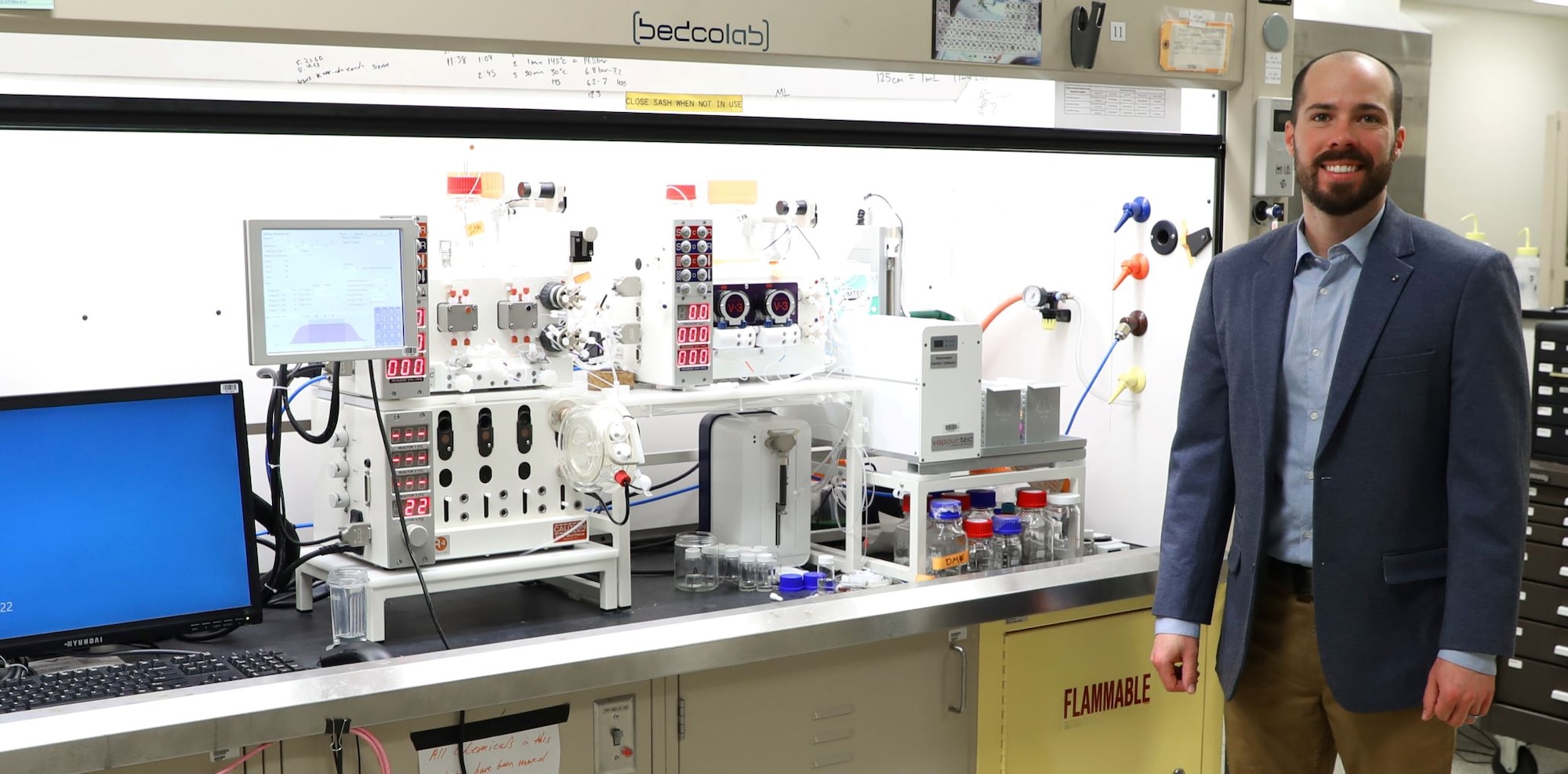 Dr. Luke Baldwin with Flow Chemistry machine. (U.S. Air Force photo/Jonathan Taulbee)