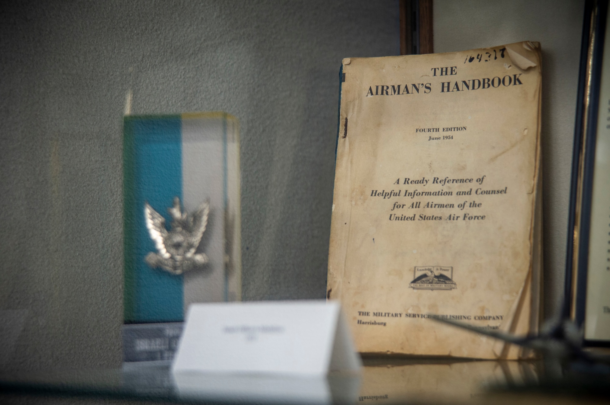 A copy of the Airman’s Handbook from 1954 is showcased in a display cabinet in the Airman Leadership School auditorium March 2, 2022, at MacDill Air Force Base, Florida. ALS is the first level of Professional Military Education that enlisted Airmen experience, teaching them entry-level leadership skills to prepare Airmen for positions of greater responsibility. (U.S. Air Force photo by Senior Airmen David D. McLoney)