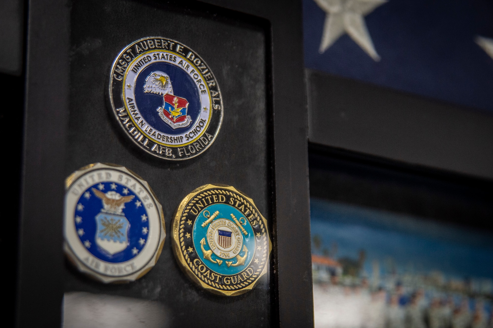 A U.S. Air Force Chief Master Sgt. Aubert E. Dozier Airman Leadership School (ALS) coin is displayed on a plaque in the ALS auditorium at MacDill Air Force Base, Florida, March 2, 2022. MacDill’s ALS was named in honor of Dozier, who was a senior enlisted advisor and was twice nominated for the position of Chief Master Sergeant of the Air Force. Dozier served as the commandant for the school from 1983 to 1985. (U.S. Air Force photo by Senior Airman David D. McLoney)