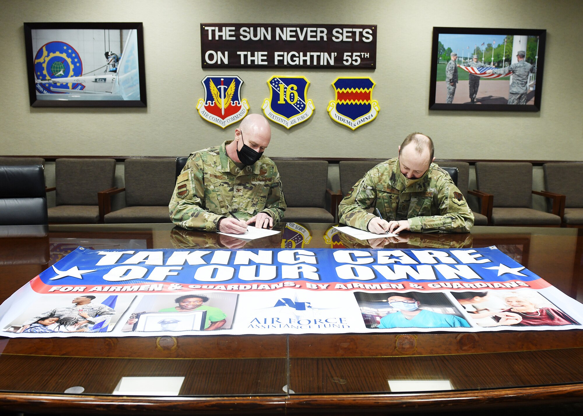 Col. Mark Howard, 55th Wing vice commander, and Chief Master Sgt. Bryan Tuman, 55th WG command chief, pose for a photo for the Air Force Assistance Fund campaign inside the 55th WG headquarters.
