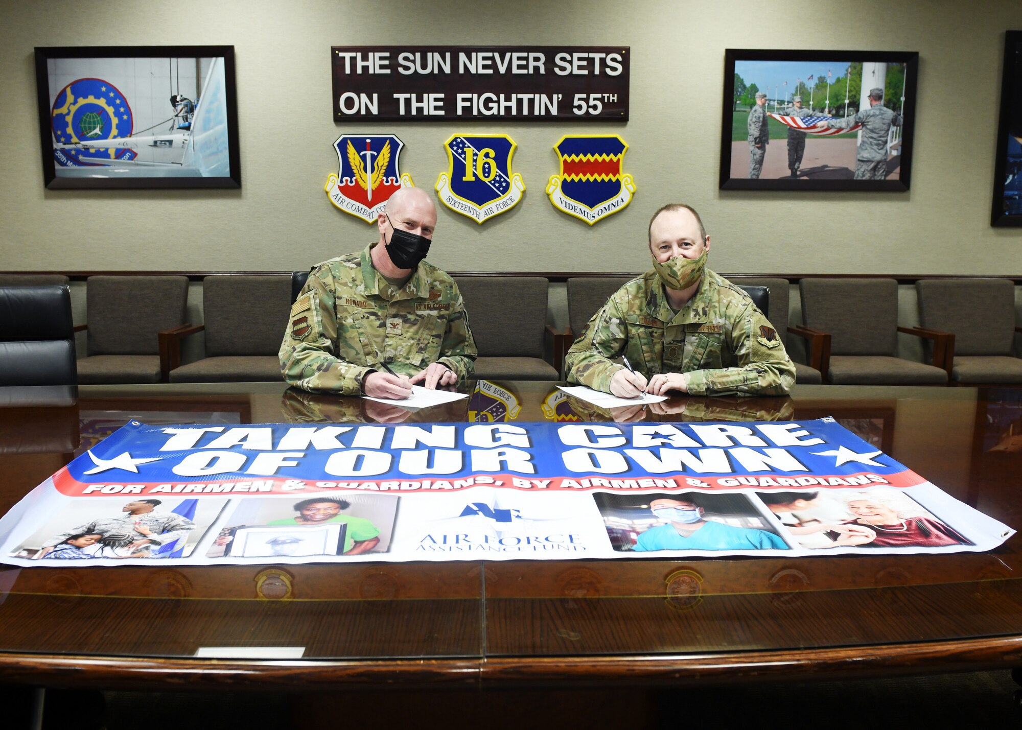Col. Mark Howard, 55th Wing vice commander, and Chief Master Sgt. Bryan Tuman, 55th WG command chief, pose for a photo for the Air Force Assistance Fund campaign inside the 55th WG headquarters.