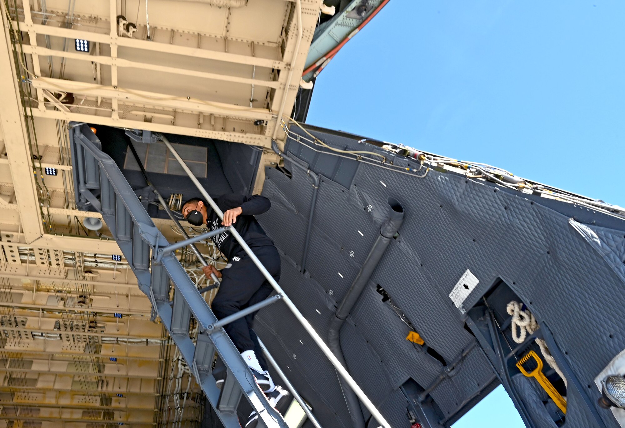 Keldon Johnson, a San Antonio Spurs basketball player, climbs the stairs to the flight deck of a C-5M Super Galaxy aircraft during his visit to the 433rd Airlift Wing at Joint Base San Antonio-Lackland, Texas, March 2, 2022. Johnson toured the aircraft, then greeted Reserve Citizen Airmen in the wing for autographs and photos. (U.S. Air Force photo by Samantha Mathison)
