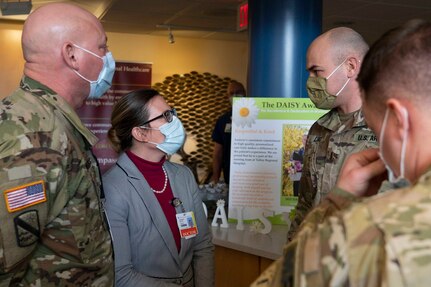 Center right, 2nd Lt. Christopher Lind, officer in charge of the Dartmouth region, meets with Dr. Juliann Barrett of Valley Regional Hospital in Claremont, New Hampshire on Jan. 25, 2022.