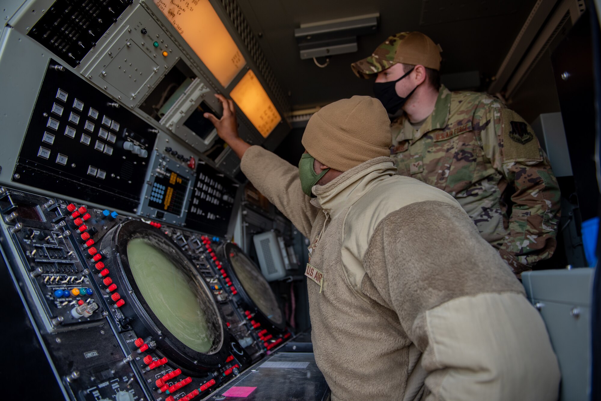 Two airmen monitor aircraft radar.