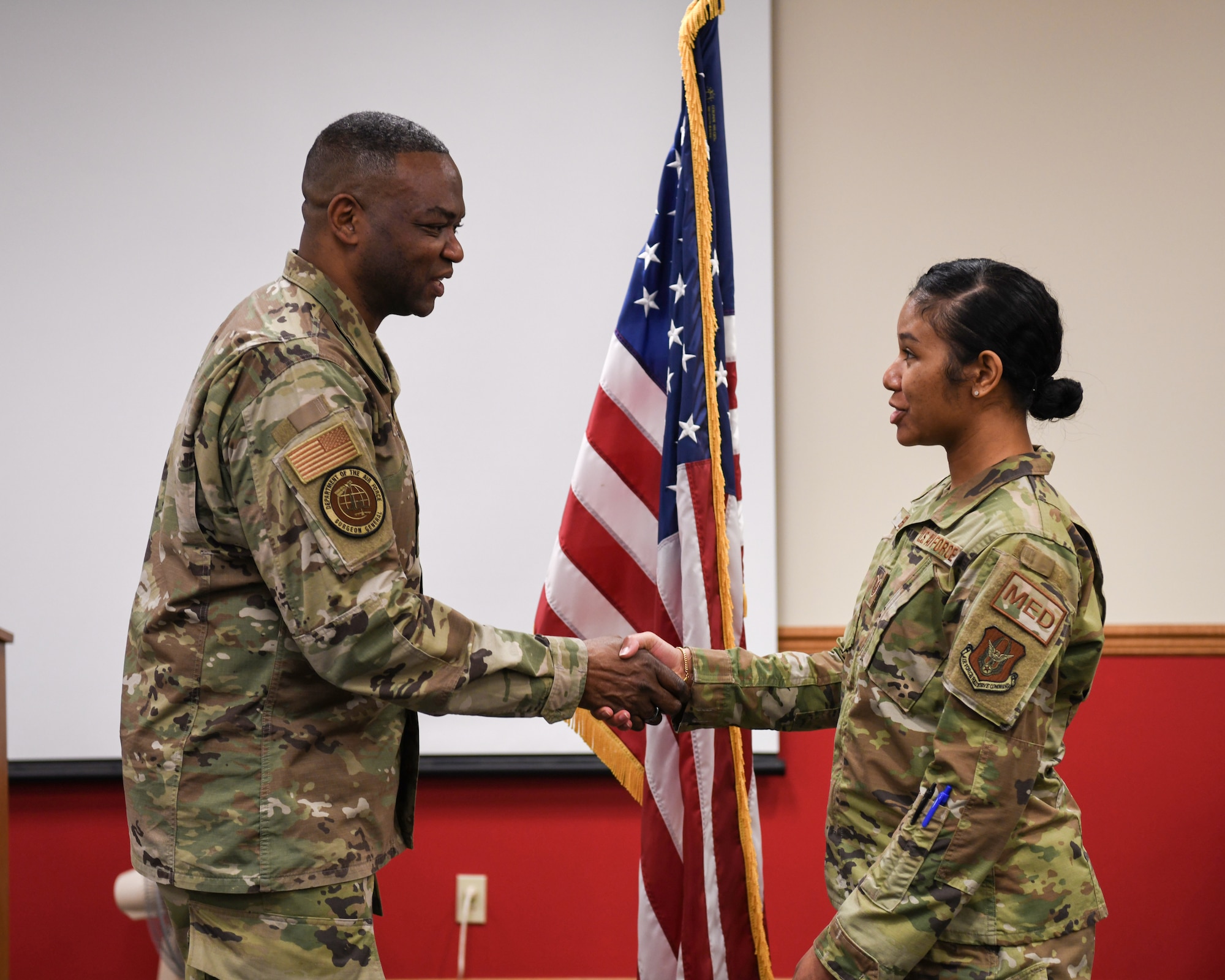 Brig. Gen. Alfred K. Flowers, Jr., Director of Manpower, Personnel and Resources, and Chief of the Medical Service Corps, Office of the Air Force Surgeon General, presents a coin to Tech. Sgt. Kathleen L. Burden, 445th Aerospace Medicine Squadron flight and operational medical technician, during his visit to Wright-Patterson Air Force Base, Ohio March 4, 2022.