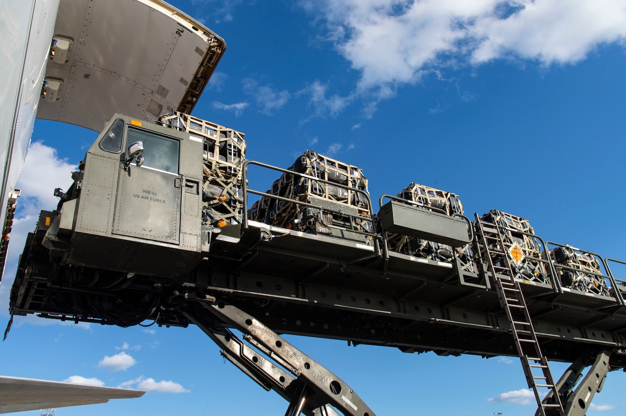 A loader raises pallets of equipment.